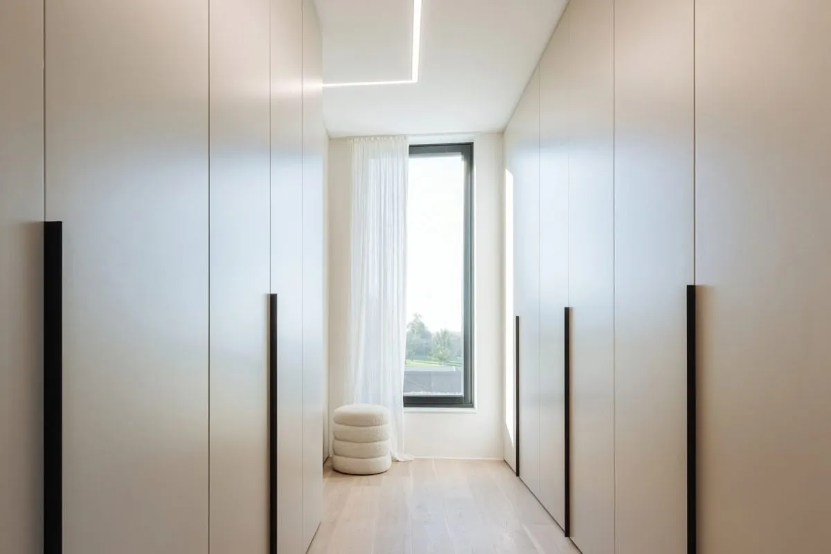 Vestidor a medida con frentes claros y tiradores verticales